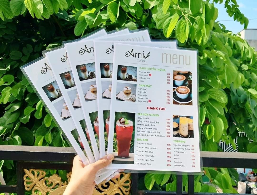 Thiết kế menu một tờ hai mặt nhỏ gọn với tone nền trắng trang nhã, phân chia danh mục rõ ràng (Cafe truyền thống, Cafe máy, Trà sữa, Trà Ami) kết hợp hình ảnh minh họa chân thực và bảng giá trực quan.