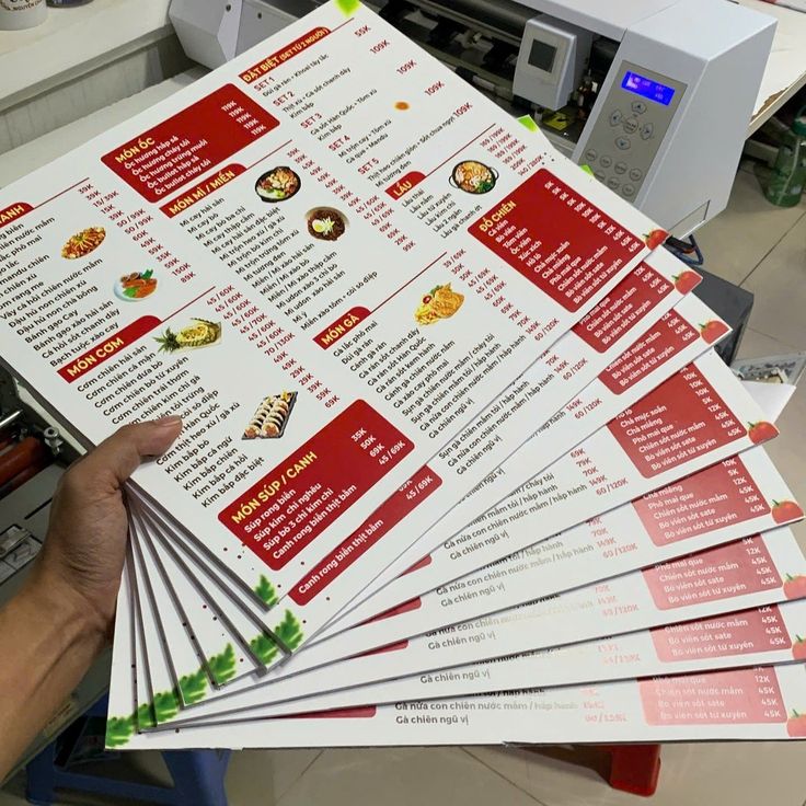 Loạt sản phẩm menu thực đơn vừa bước ra từ máy gia công, sử dụng tone màu đỏ - trắng bắt mắt, phân chia khoa học các danh mục món ăn, combo đặc biệt và đồ uống với hình ảnh sắc nét, không lo bong tróc hay thấm nước trong quá trình sử dụng.